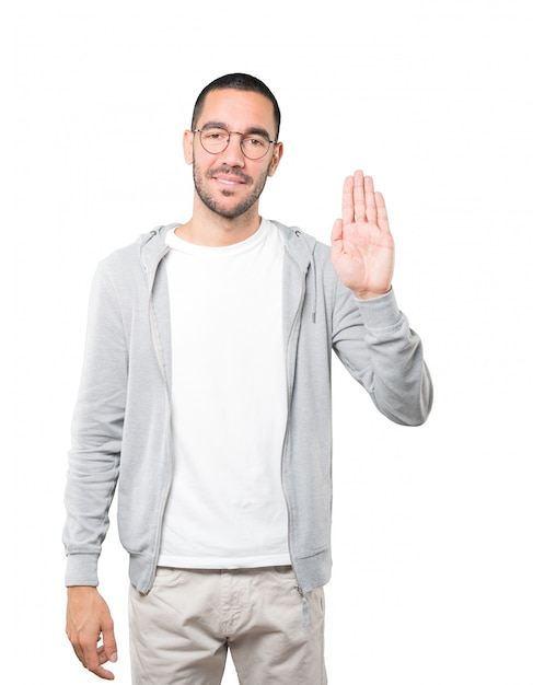 Happy young man making a gesture of stop with his palm