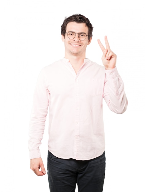 Happy young man making a victory gesture with his fingers