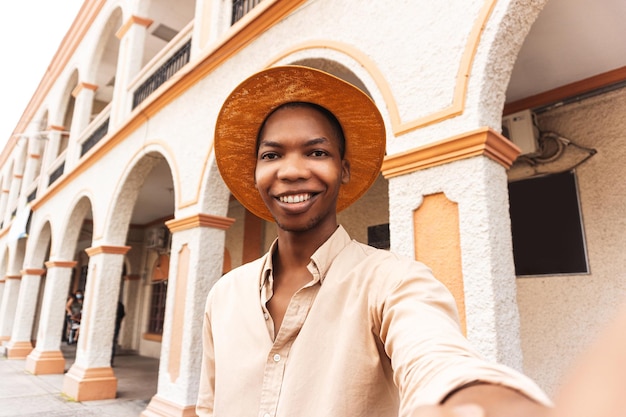 Happy young man millennial taking a selfie smiling at the\
camera near colonial city of honduras