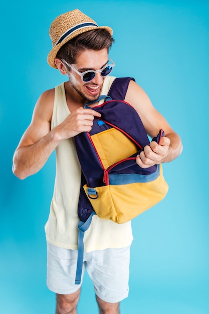 Happy young man opening his bag