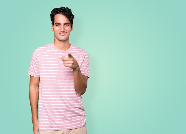 Happy young man pointing at you with his finger