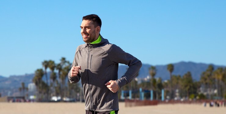 Photo happy young man running over venice beach