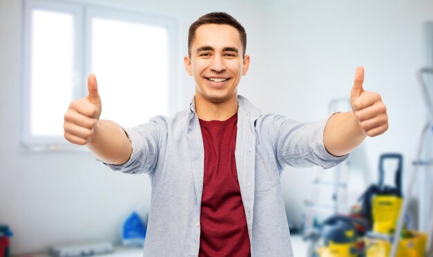 Photo happy young man showing thumbs up over home repair