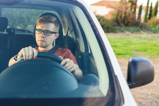 車の中で座っている幸せな若い男。