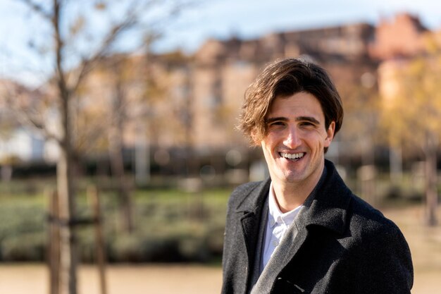 Happy young man smiling in park