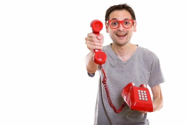 happy young man smiling while giving old telephon