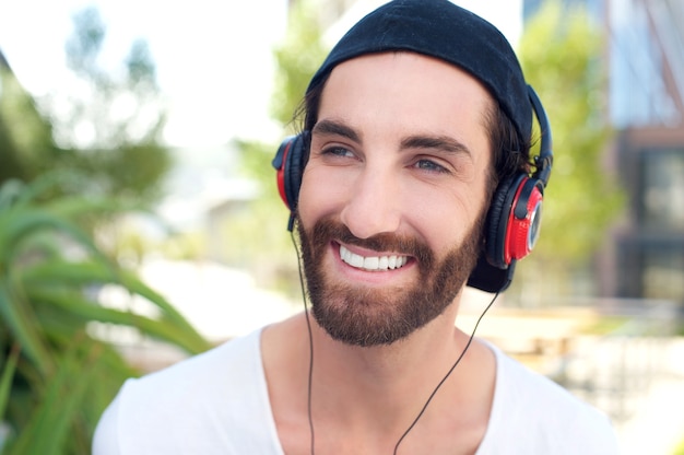 Happy young man smiling with headphones outdoors