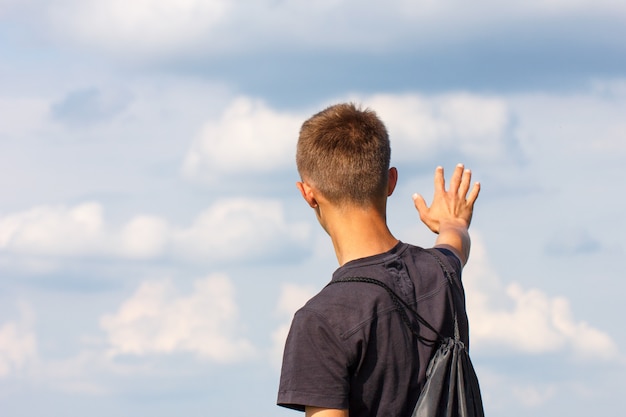 彼の手で上に立って幸せな若い男