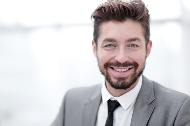 Happy young man in suit looking at camera with toothy smile