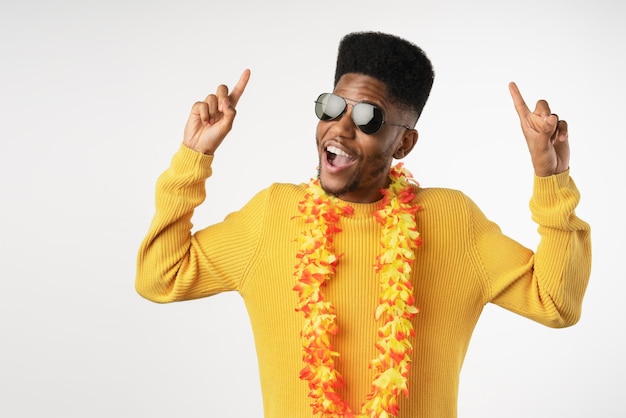 Happy young man in sunglasses pointing at copy space and isolated on white background