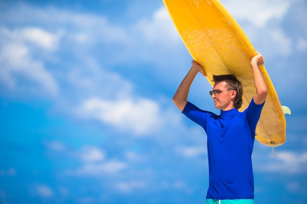 Happy young man surfing on the tropical coast