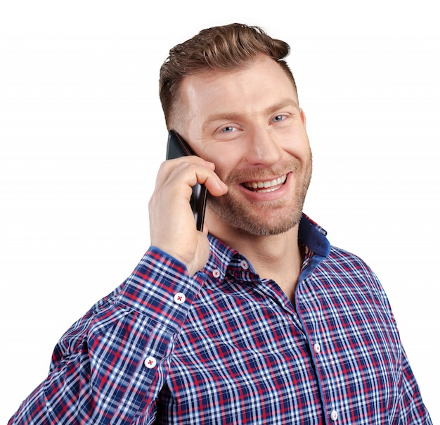 Счастливый молодой человек разговаривает по мобильному телефону