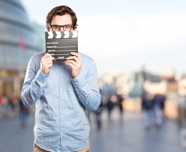 Happy young man using a clapperboard