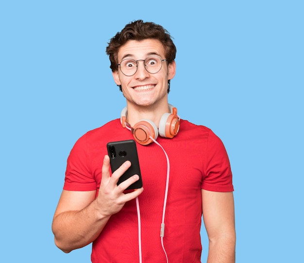 Happy young man using headphones and a smartphone