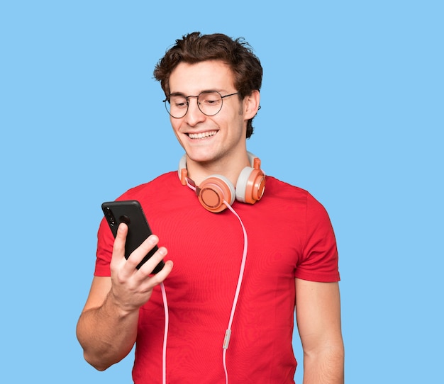 Happy young man using headphones and a smartphone