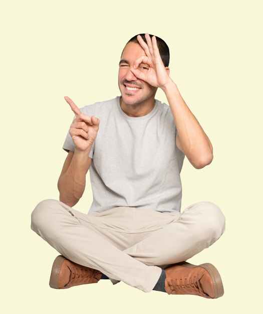 Happy young man using his hands like a binoculars