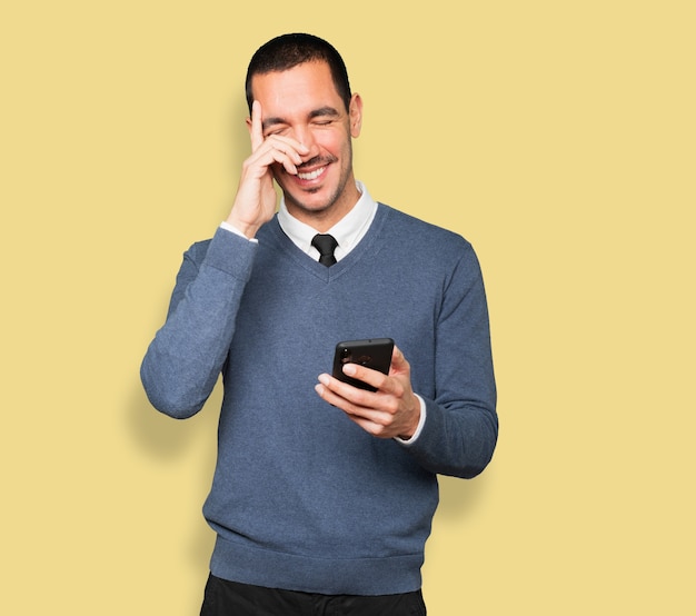 Happy young man using his mobile phone