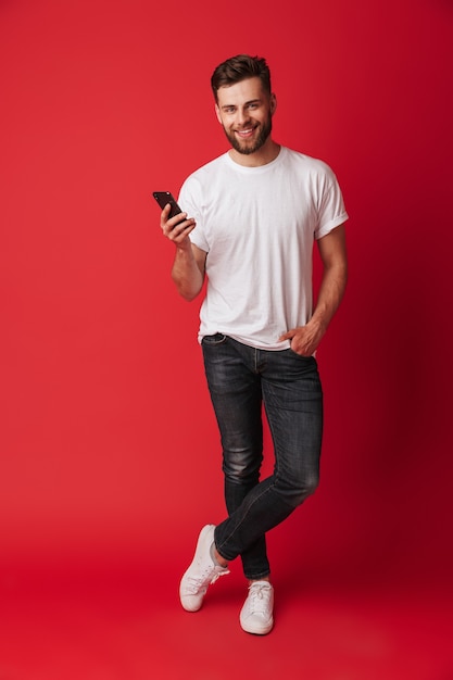 Happy young man using mobile phone.