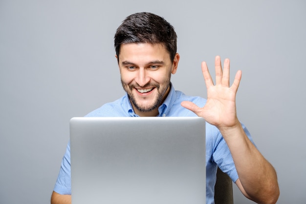 Happy young man video chatting on laptop computer