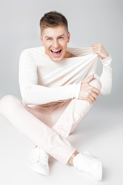 Happy young man in a white sweater