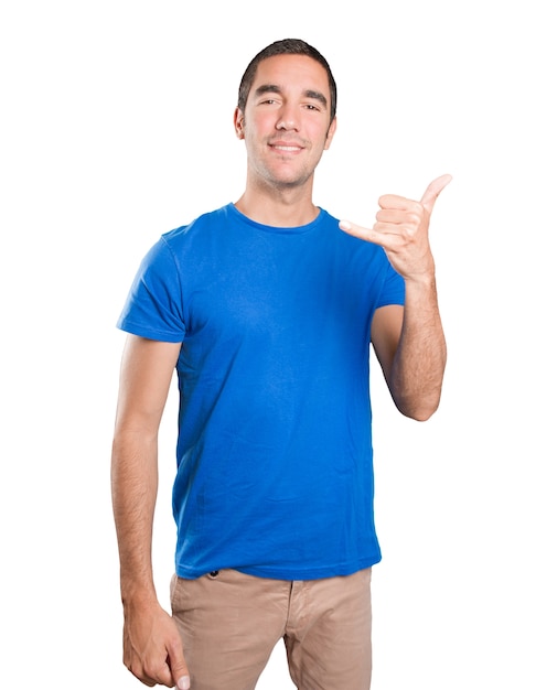 Happy young man with call gesture against white background