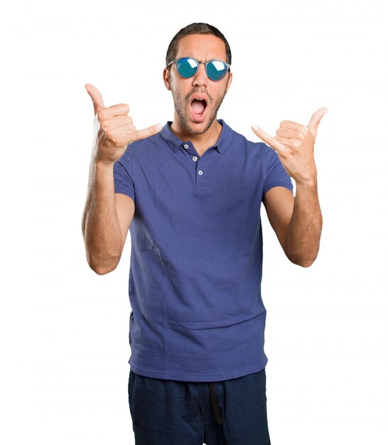 Happy young man with call gesture on white background