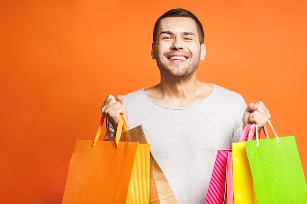 Happy young man with colorful paper bags