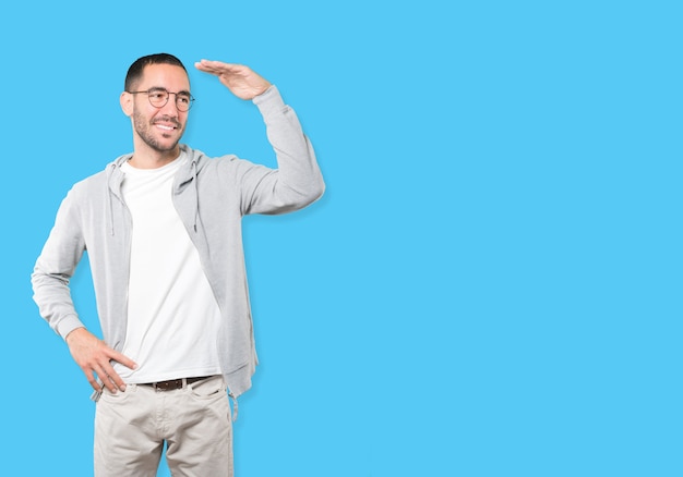 Happy young man with a gesture of looking away