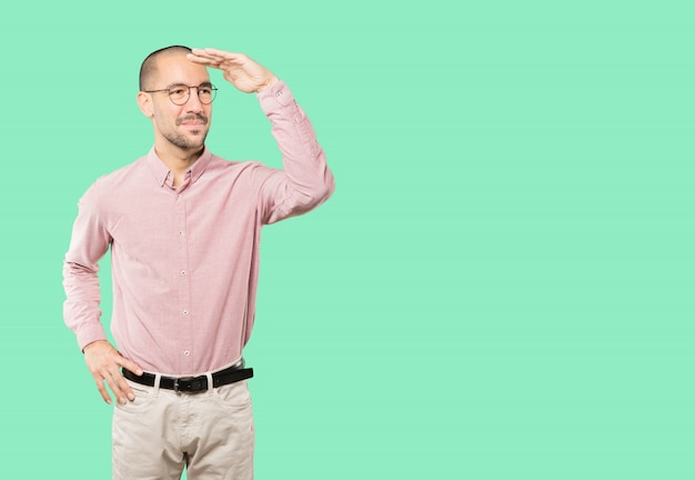 Happy young man with a gesture of looking away