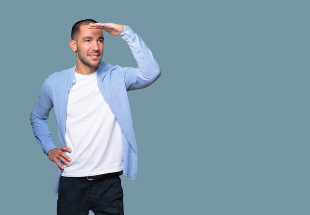 Happy young man with a gesture of looking far