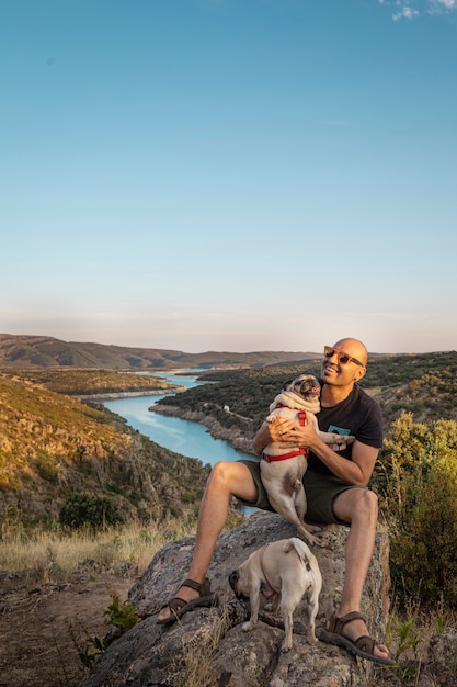 Foto felice giovane con il suo cane in montagna