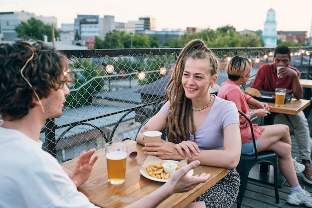 Happy young man and woman having date in outdoor cafe