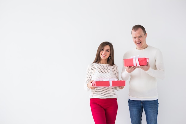 Felice giovane uomo e donna con scatole regalo rosse