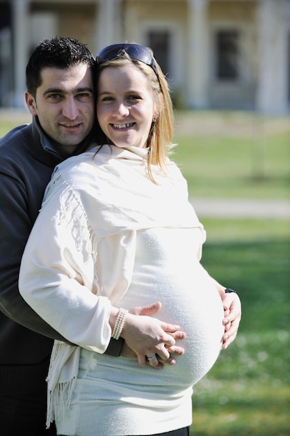 Photo happy young married family couple outdoor in nature have fun and waiting baby and representing young family growth and pregnancy concept