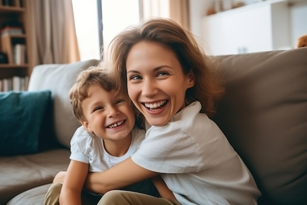 Happy young mother and little son having fun on cozy couch in living room