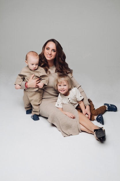 Happy young mother posing at camera together with her kids