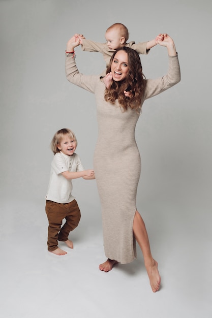 Happy young mother posing at camera together with her kids