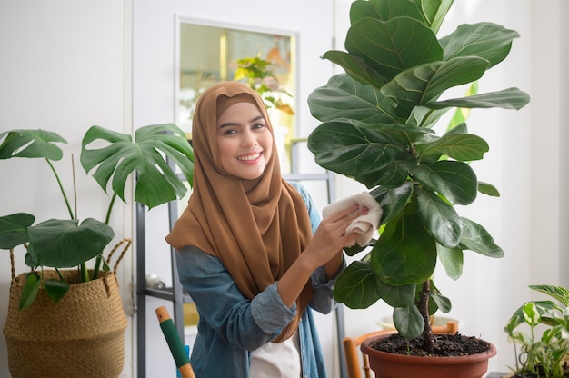 Счастливая молодая мусульманская женщина, наслаждающаяся и расслабляющая досуг в саду дома