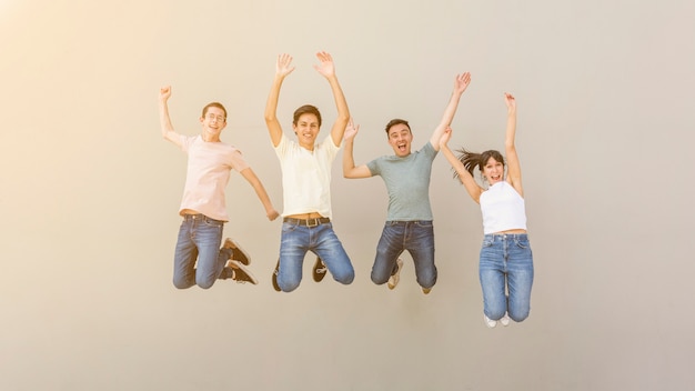 Счастливые молодые люди прыгают вместе