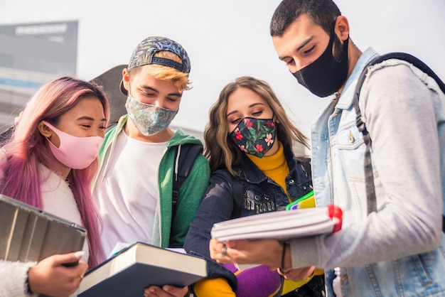 Happy young people meeting outdoors and wearing face masks\
during covid19 pandemic