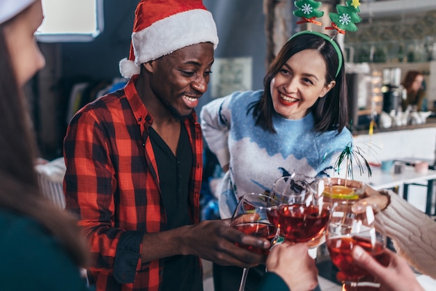 Happy young people with glasses celebrating Christmas