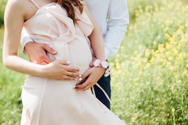 Happy and young pregnant couple hugging