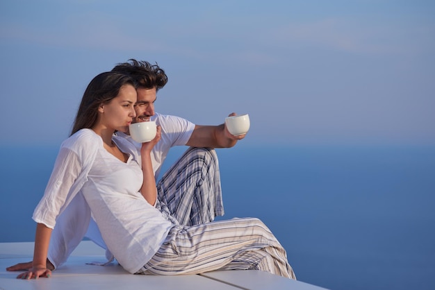 happy young romantic couple have fun relax smile at modern home outdoor terace balcony terace