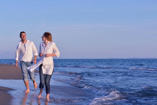 happy young romantic couple in love have fun on beautiful beach at beautiful summer day