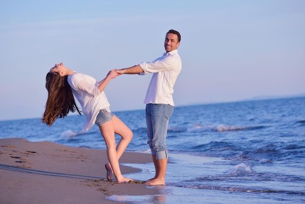 happy young romantic couple in love have fun on beautiful beach at beautiful summer day