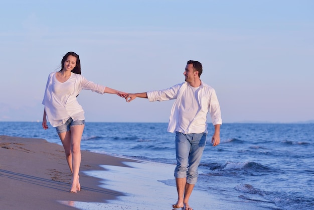 happy young romantic couple in love have fun on beautiful beach at beautiful summer day