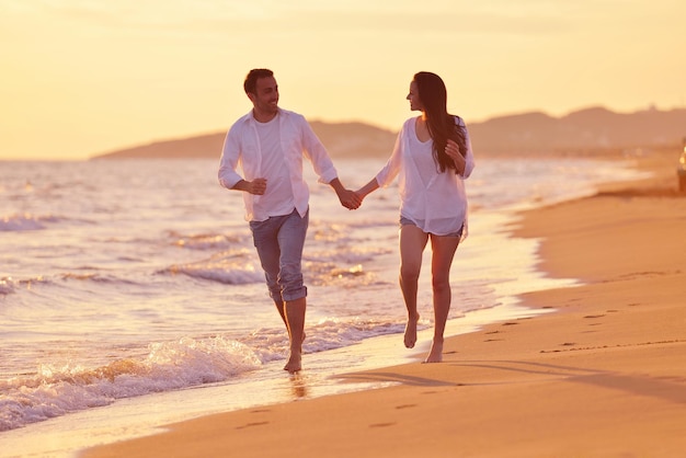 Felice giovane coppia romantica innamorata divertirsi sulla bellissima spiaggia in una bella giornata estiva