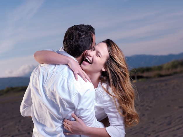 Felice giovane coppia romantica innamorata divertirsi sulla bellissima spiaggia in una bella giornata estiva