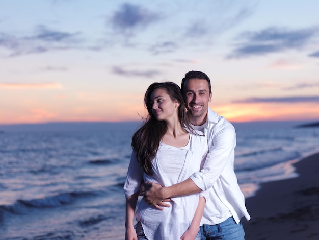 Felice giovane coppia romantica innamorata divertirsi sulla bellissima spiaggia in una bella giornata estiva