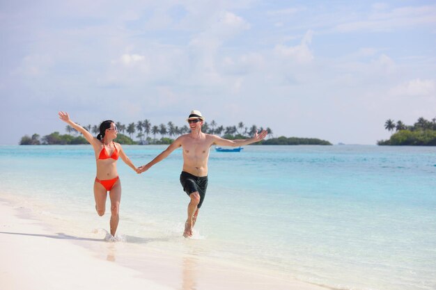 Happy young romantic couple in love have fun running and relaxing on beautiful beach